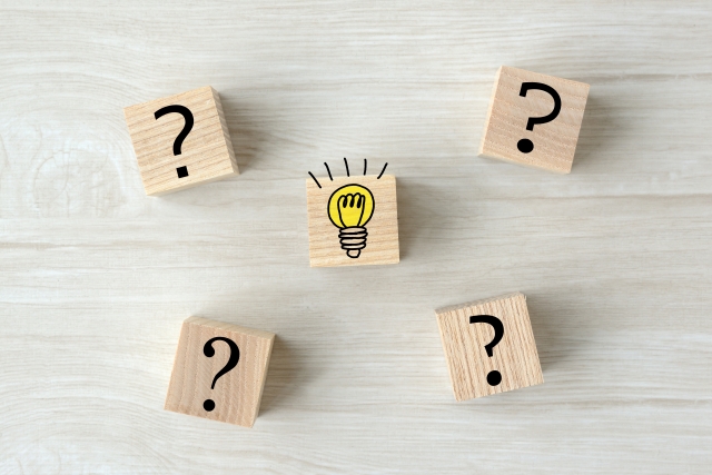 ？マークと電球のイラストが描かれた木のブロック