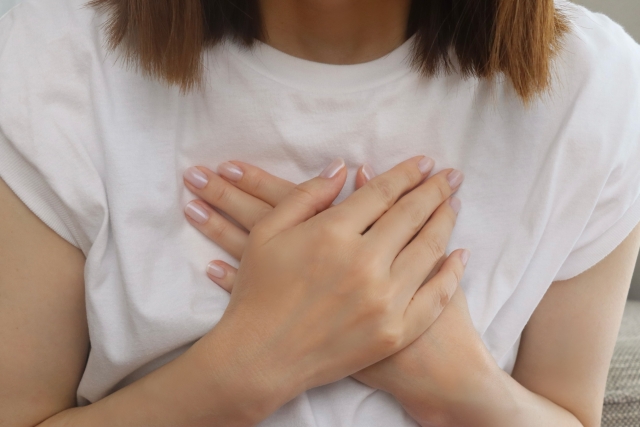 胸に手を当てている女性