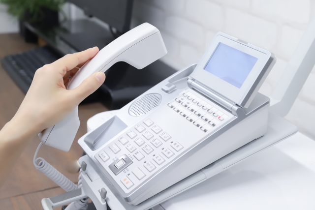 ビジネスフォンを持つ手