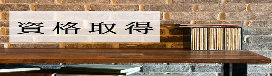 レンガ壁の前に置かれた棚と本、『資格取得』の文字が書かれた白い背景」