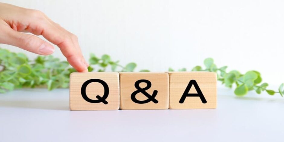 木製ブロックに「Q&A」の文字と指、背景に観葉植物