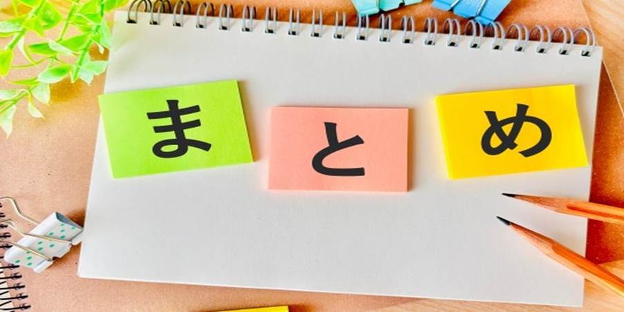 『まとめ』と書かれた付箋とノート・文房具が並ぶデスク上のカラフルな構成