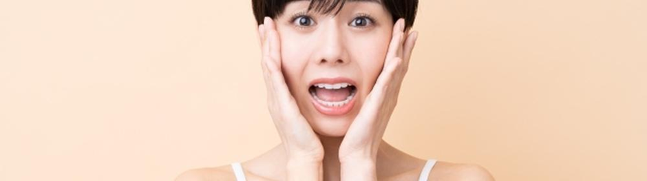 驚いた表情で顔を押さえる女性