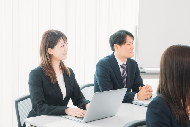 話を聞いているスーツの男女