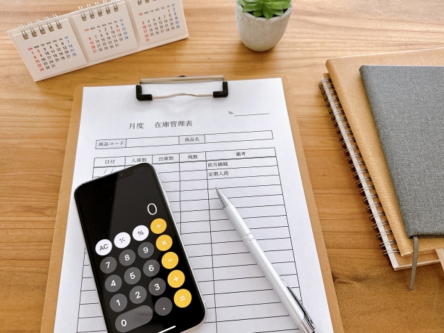 在庫管理表と電卓アプリを表示しているスマホ