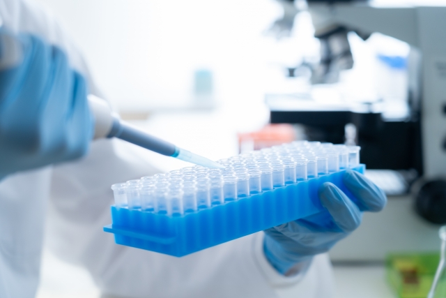 試験管に入ったサンプルに薬剤を注入している様子