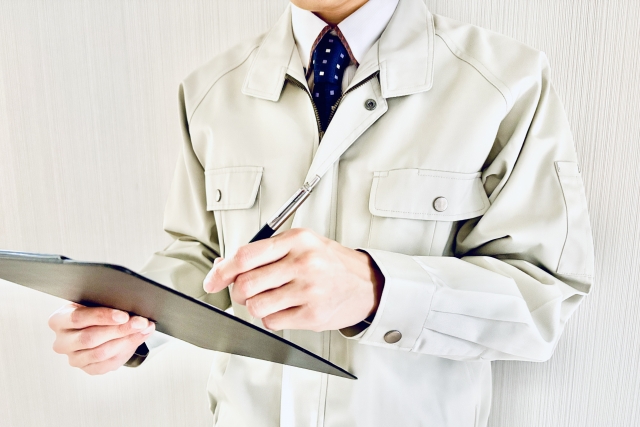 バインダーに書き込む男性作業員