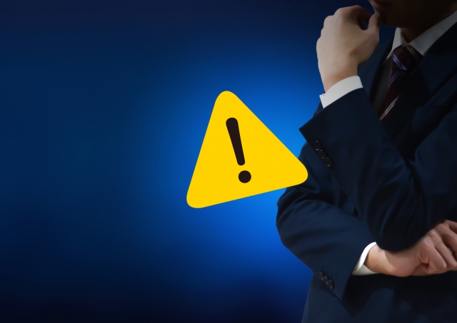 腕を組むビジネスマンとビックリマーク