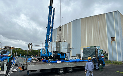 クレーンでPCB含有電気機器を積み込んでいる様子