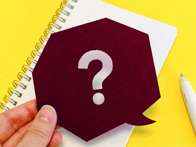 ハテナが描かれた紙を持つ手元